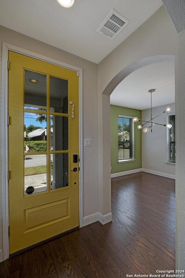 foyer entrance featuring dark hardwood / wood-style flooring and an inviting chandelier