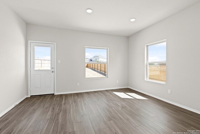 unfurnished living room featuring sink, a healthy amount of sunlight, and dark hardwood / wood-style floors