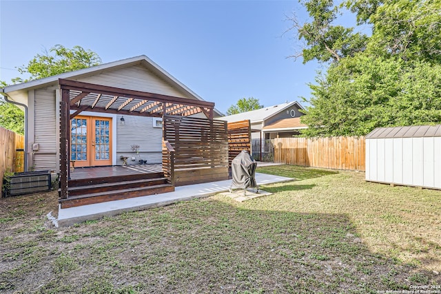 rear view of house featuring a storage shed, french doors, a yard, and a wooden deck