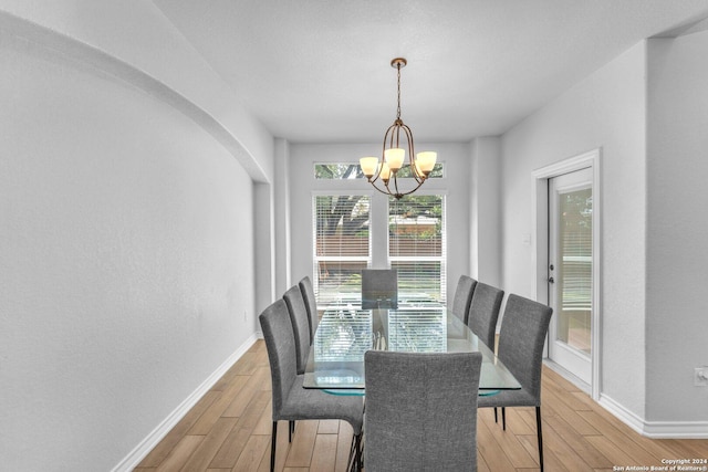 dining area with an inviting chandelier and light hardwood / wood-style floors