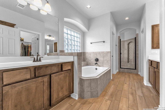 bathroom featuring vanity and shower with separate bathtub