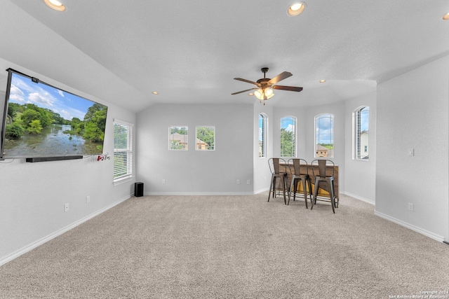 interior space with ceiling fan, lofted ceiling, and a textured ceiling