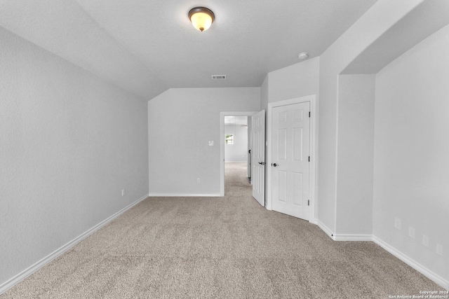 bonus room with light colored carpet, lofted ceiling, and a textured ceiling