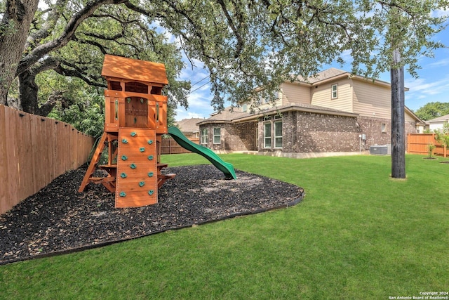 view of playground with a yard and central AC unit