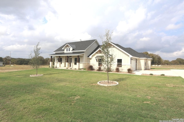 view of front of home with a garage, a front lawn, and a porch