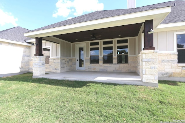 back of house featuring ceiling fan and a yard