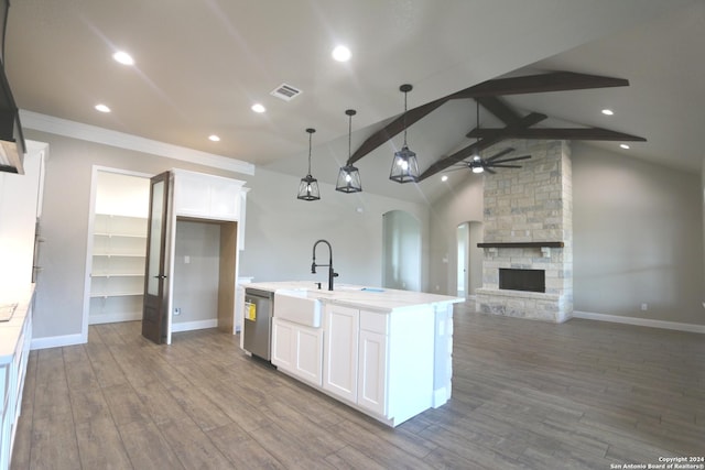 kitchen featuring ceiling fan, white cabinetry, an island with sink, decorative light fixtures, and stainless steel dishwasher