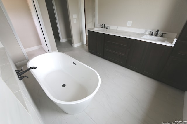 bathroom featuring tiled bath and vanity