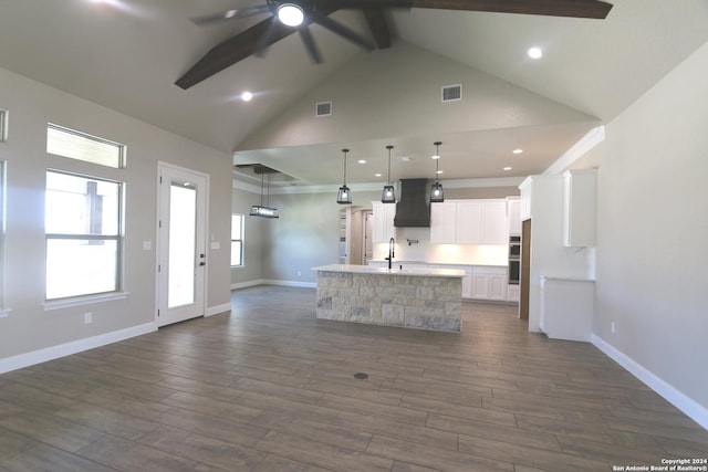 kitchen with dark hardwood / wood-style floors, pendant lighting, an island with sink, white cabinets, and ceiling fan