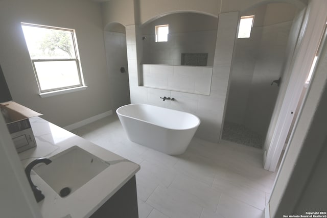 bathroom with vanity, plus walk in shower, tile patterned flooring, and a healthy amount of sunlight