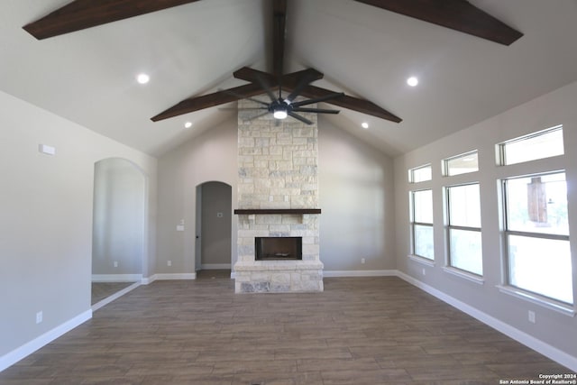 unfurnished living room featuring beam ceiling, high vaulted ceiling, dark wood-type flooring, and a fireplace