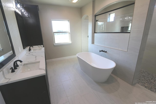 bathroom with vanity and independent shower and bath