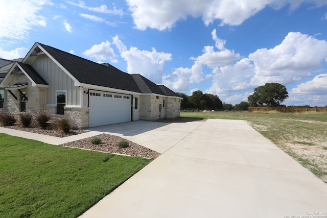 view of side of property with a lawn and a garage