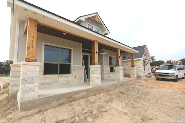 rear view of property with covered porch