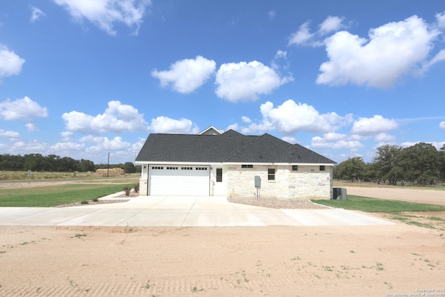 view of front of property featuring a garage and central AC