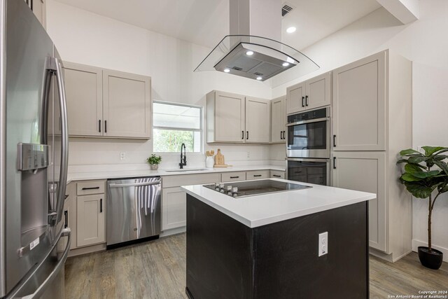 kitchen with stainless steel appliances, wood-type flooring, a kitchen island, and island exhaust hood