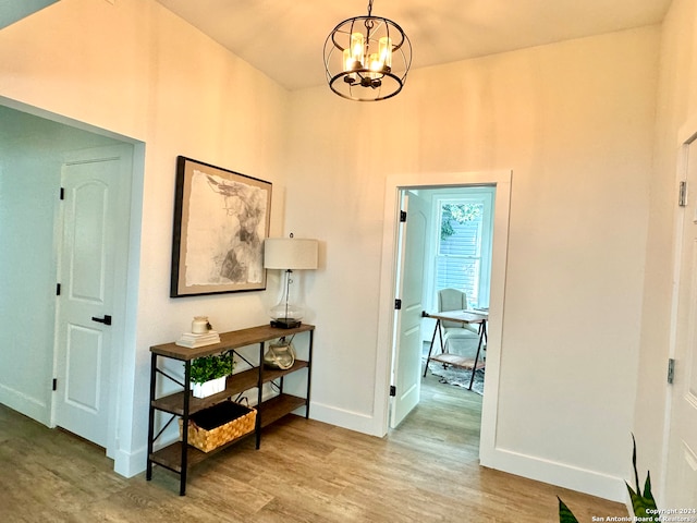 corridor featuring a notable chandelier and wood-type flooring