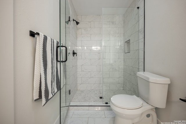 bathroom with tile patterned floors, toilet, and a shower with door