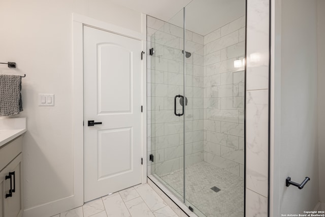 bathroom featuring a shower with shower door, vanity, and tile patterned floors