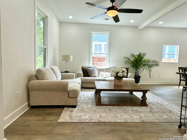 living room featuring beamed ceiling, wood-type flooring, and ceiling fan