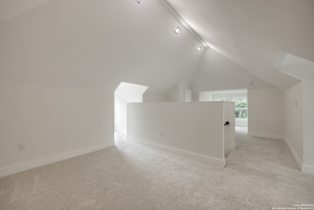 bonus room featuring lofted ceiling and light carpet