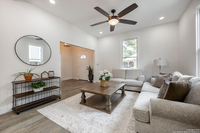 dining room with beam ceiling, ceiling fan with notable chandelier, and hardwood / wood-style floors