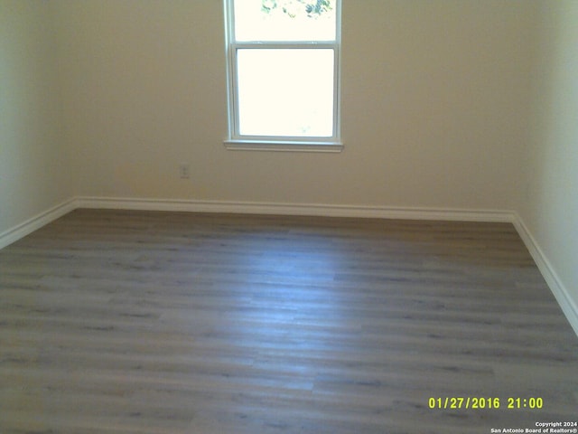 unfurnished room with wood finished floors and baseboards