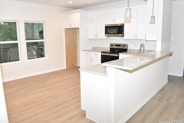 kitchen with light stone counters, appliances with stainless steel finishes, light wood-style flooring, and white cabinetry