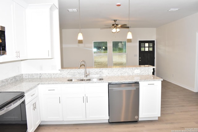 kitchen with light stone counters, stainless steel appliances, a peninsula, a sink, and white cabinetry