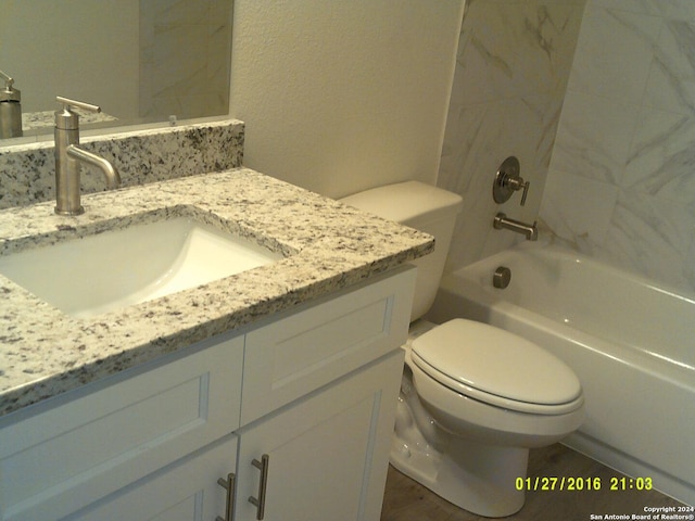 bathroom with toilet, shower / tub combination, and vanity