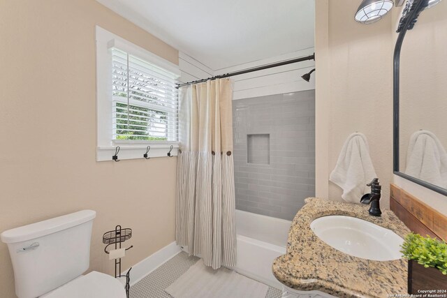 full bathroom with tile patterned flooring, toilet, shower / bathtub combination with curtain, and sink