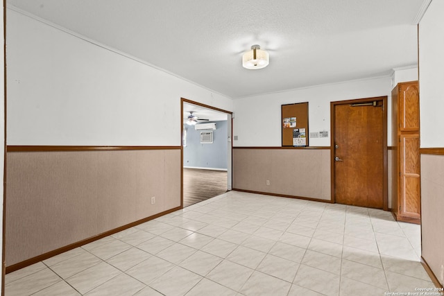 empty room featuring a textured ceiling, an AC wall unit, and ceiling fan