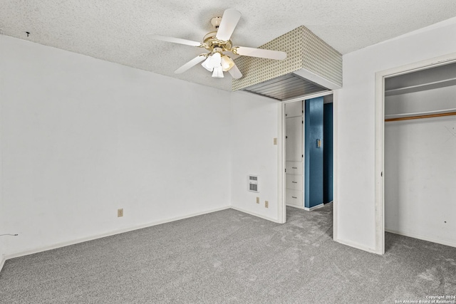 unfurnished bedroom featuring ceiling fan, a closet, a textured ceiling, and carpet flooring