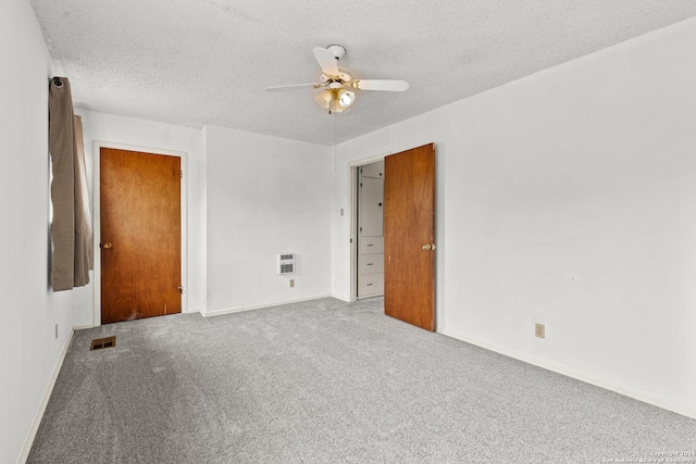 carpeted spare room featuring heating unit, ceiling fan, and a textured ceiling