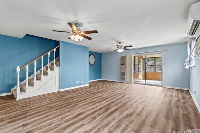 unfurnished living room with hardwood / wood-style flooring, ceiling fan, a wall mounted AC, and a textured ceiling