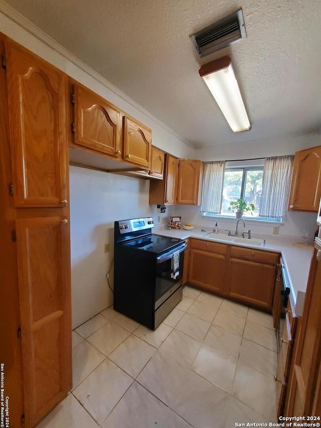 kitchen with light tile patterned flooring, sink, electric range, and a textured ceiling