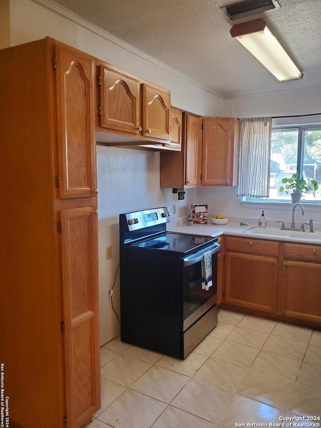 kitchen featuring light tile patterned flooring, sink, a textured ceiling, and electric range