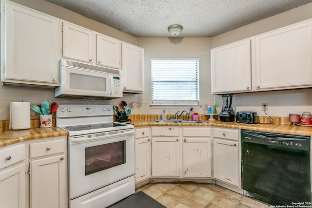 kitchen featuring white cabinetry, sink, white appliances, and a textured ceiling