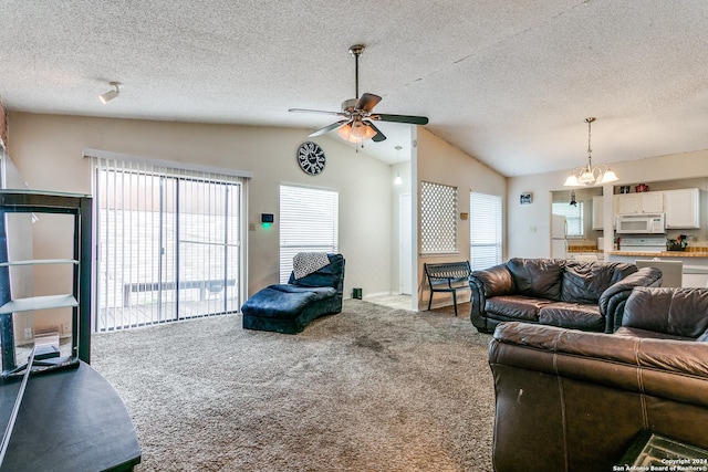 living room featuring ceiling fan with notable chandelier, carpet floors, vaulted ceiling, and a textured ceiling