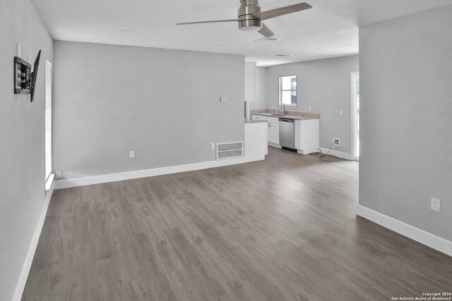 unfurnished living room featuring sink, wood-type flooring, and ceiling fan