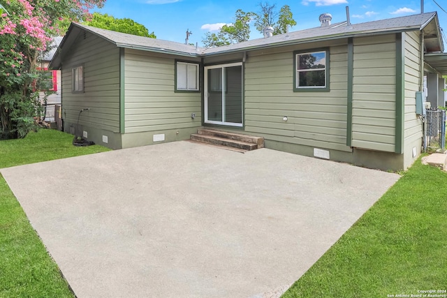 rear view of property with a yard and a patio