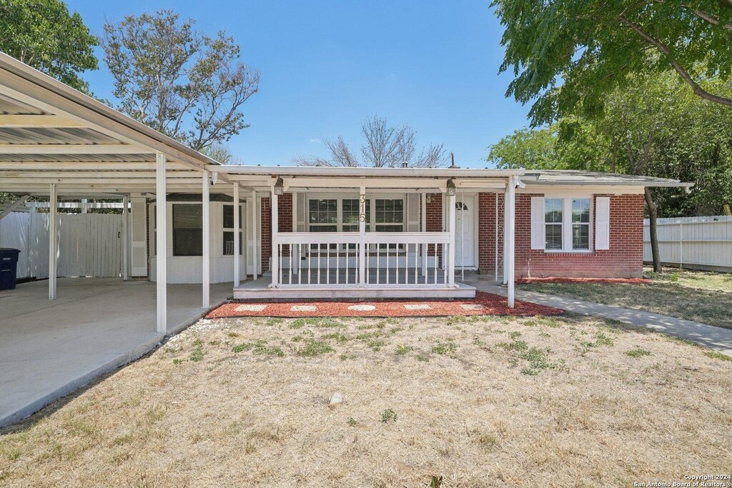 view of front of house featuring central AC unit, a carport, and covered porch