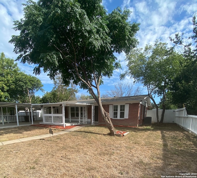 view of front of house featuring central AC unit, a carport, and covered porch