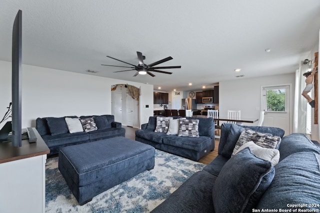 living room featuring hardwood / wood-style floors and ceiling fan