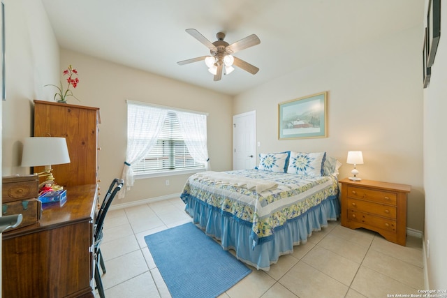 bedroom with light tile patterned flooring, a ceiling fan, and baseboards