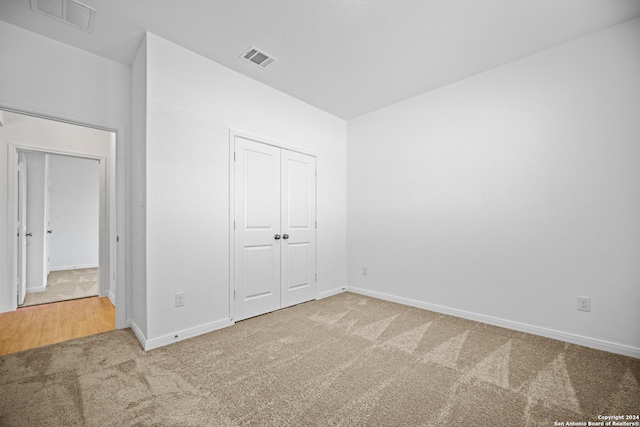 unfurnished bedroom with carpet floors and a closet