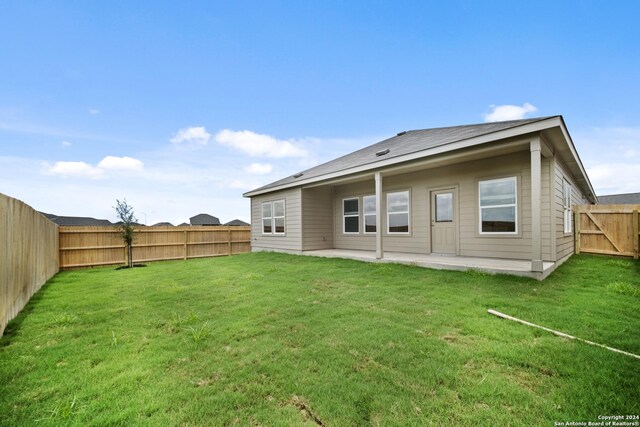 back of house featuring a patio and a yard