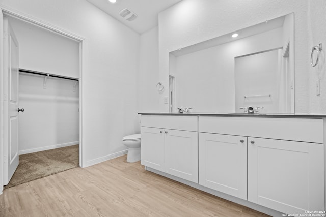 bathroom with vanity, hardwood / wood-style flooring, and toilet