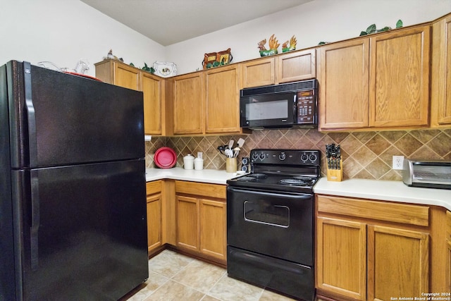 kitchen with black appliances, light tile patterned floors, and backsplash