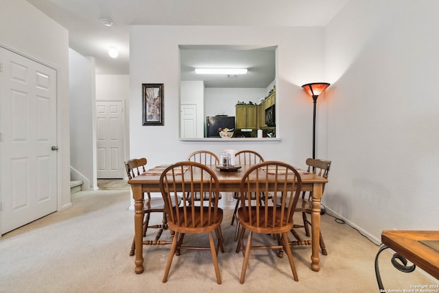 dining area featuring light carpet